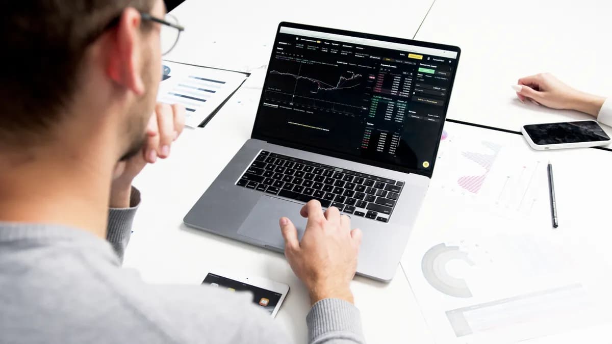 trader analysant des graphiques sur ordinateur pour vivre du trading à plein temps
